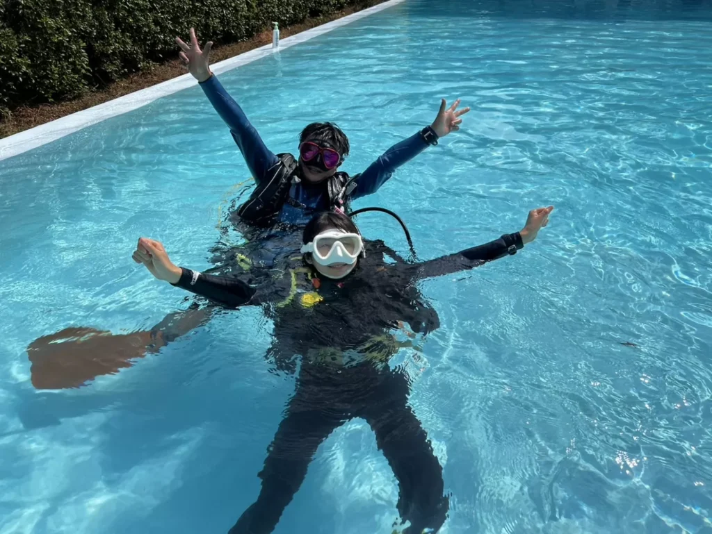 Diving students practicing basic scuba skills in a swimming pool during a PADI course in Phuket