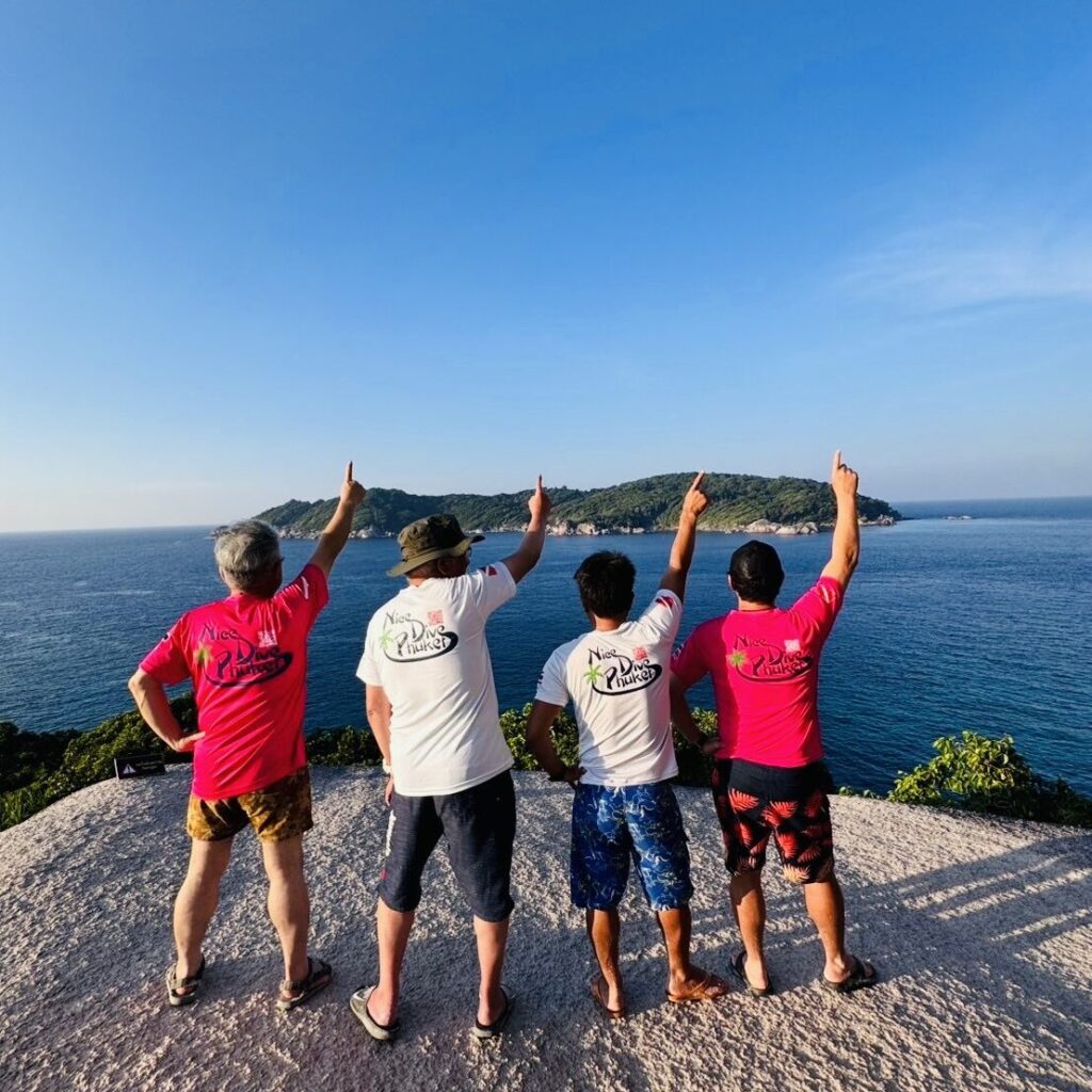 Nice Dive Phuket staff pointing toward the ocean from a scenic viewpoint