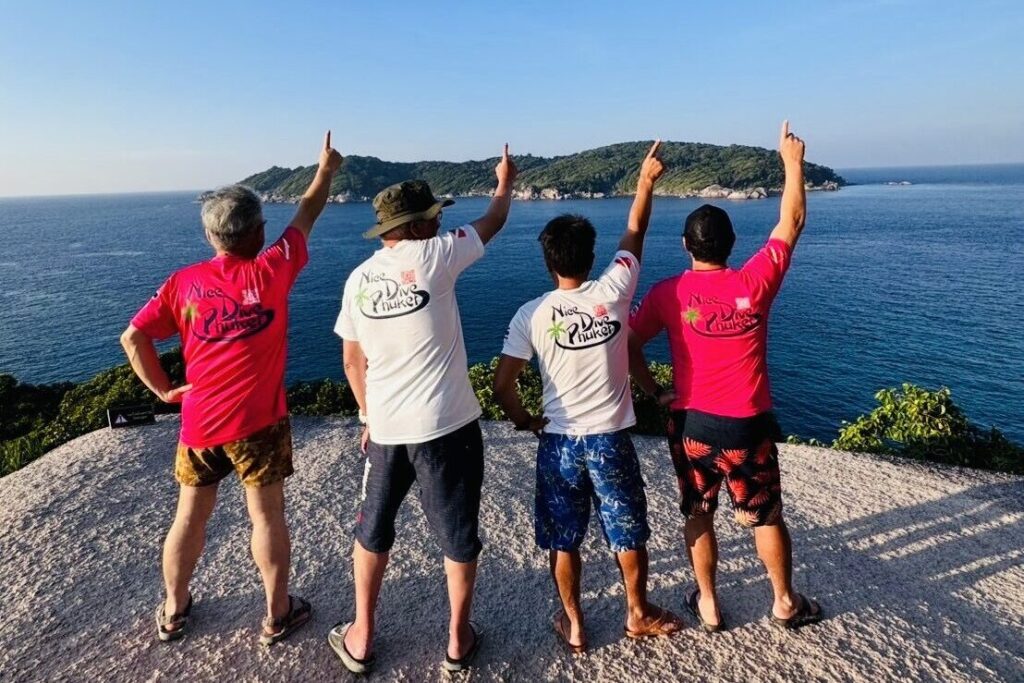 Nice Dive Phuket staff pointing toward the ocean from a scenic viewpoint